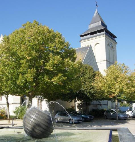 a large building with a clock tower with a fountain at Logis Loire Hotel - Les Cocottes Restaurant in Les Rosiers-sur-Loire