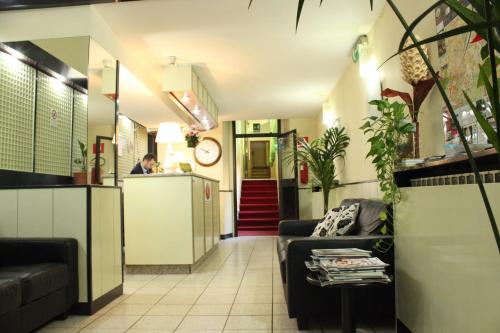 a lobby of a store with a man at the counter at Hotel Europa in Sesto San Giovanni