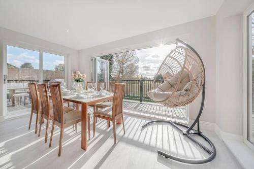 a dining room with a table and a floor fan at Luxury new build 5-Bed Bungalow-Long Stay Offer in Winkfield