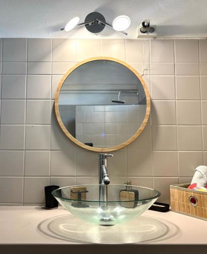 a sink in a bathroom with a mirror at Le Gîte Ohana - Proches des plages et jardin privé in Saint-François