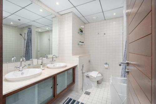 a bathroom with two sinks and a toilet at 2 Bedroom Apartment full Marina View in Dubai