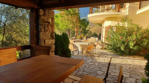 an outdoor patio with a wooden table and chairs at Private Villa with Panoramic View in Ayía Evthimía
