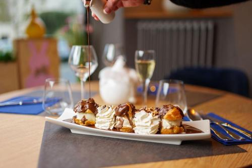 a plate of desserts on a table with wine glasses at Logis Loire Hotel - Les Cocottes Restaurant in Les Rosiers-sur-Loire