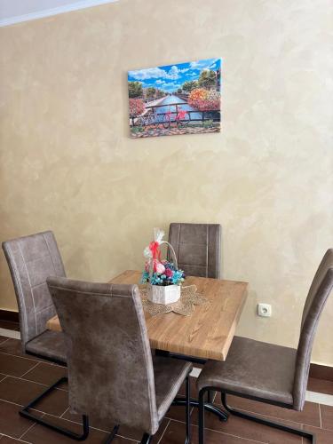 a dining room table with chairs and a painting on the wall at Dale apartment Becici- Paradiso in Budva
