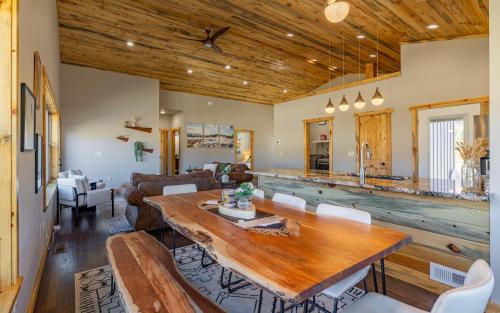 a dining room and living room with a wooden table at The Yellowstone - Spacious Wapiti Valley Cabin with Stunning Views! in Wapiti