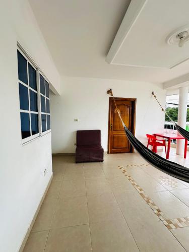 a room with a hammock in the middle of a room at HOSTAL CASA ALFON BURITACA in Santa Marta