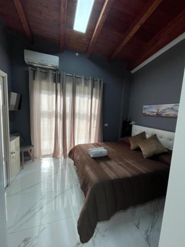 a bedroom with a large bed and a window at Alma Suite Bed and Breakfast in Nettuno