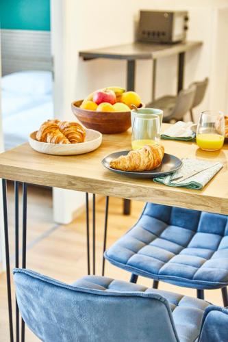 - une table avec deux assiettes de pâtisseries et de fruits dans l'établissement BE-4D - Appartement F3 pour 1-4 pers au 4ème étage au centre de Mulhouse, à Mulhouse