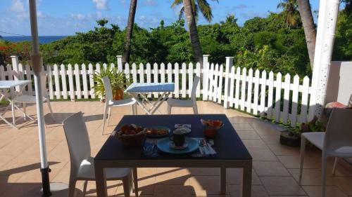 a table with a plate of food on a patio at Le M Hotel Marie Galante in Beauregard