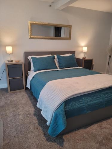 a bedroom with a large bed with blue pillows at Sunstone House in Portland