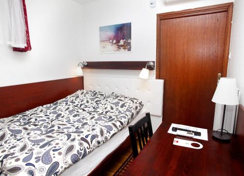 a bedroom with a bed and a table with a lamp at Guest House Isabel in Zagreb