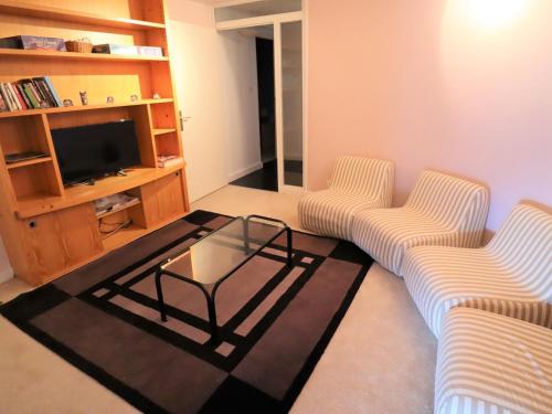 - un salon avec deux chaises et une table basse en verre dans l'établissement Grand chalet à Avoriaz pour 12 pers avec cheminée, terrasse et vue - FR-1-633-50, à Morzine