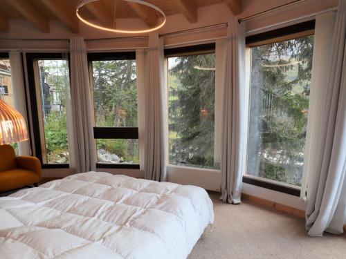 a bedroom with a large bed and large windows at Grand chalet à Avoriaz pour 12 pers avec cheminée, terrasse et vue - FR-1-633-50 in Morzine