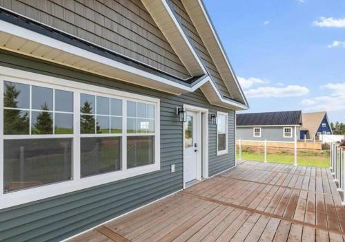 a house with a wooden deck with a door at The Perfect Getaway in Bedeque