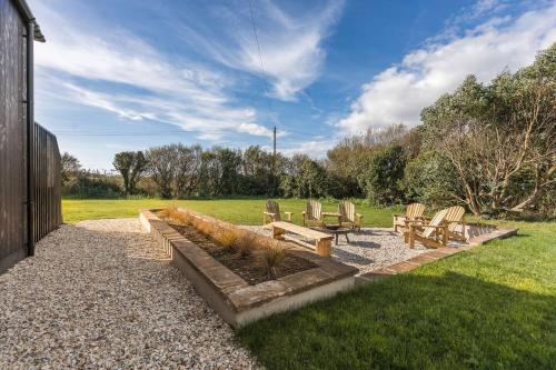 a group of chairs and benches in a yard at Alynfa Barn House Rhosniegr in Rhosneigr
