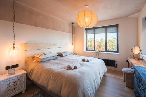 a bedroom with a large bed with two towels on it at Alynfa Barn House Rhosniegr in Rhosneigr