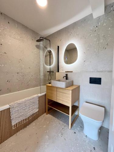 a bathroom with a sink and a toilet at Alynfa Barn House Rhosniegr in Rhosneigr