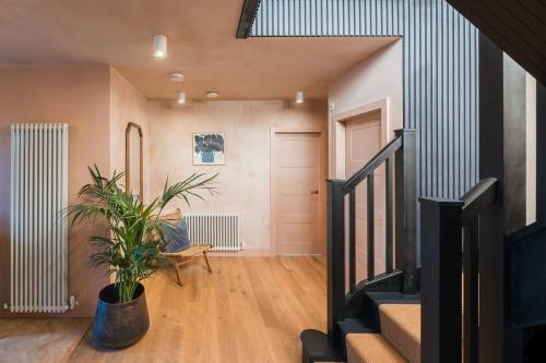 a living room with a staircase and a potted plant at Alynfa Barn House Rhosniegr in Rhosneigr