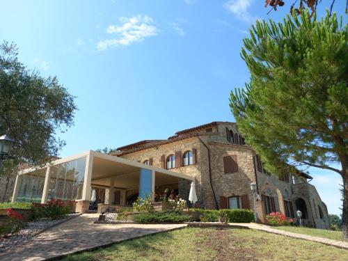 an external view of a building with trees at Antico Borgo Carceri & Wellness in Bevagna