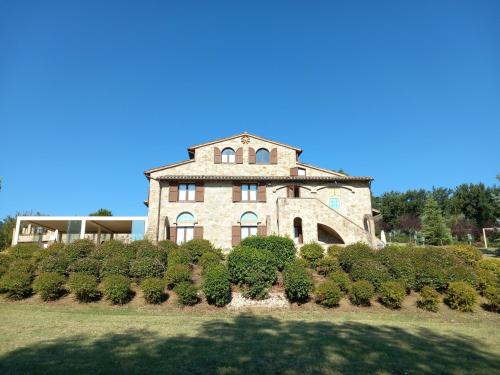 a large stone building on top of a field at Antico Borgo Carceri & Wellness in Bevagna