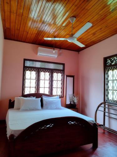 a bedroom with a large bed with a wooden ceiling at Golden Glade in Weligama