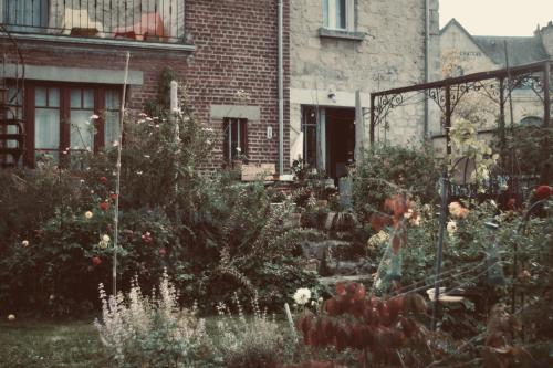 a garden in front of a brick house at Chez Ric et Fer in Coucy-le-Château-Auffrique