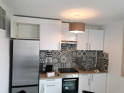 eine Küche mit weißen Schränken und schwarzen und weißen Fliesen in der Unterkunft Au Saint-Hubert, Appartement 3 chambres Valenton in Valenton