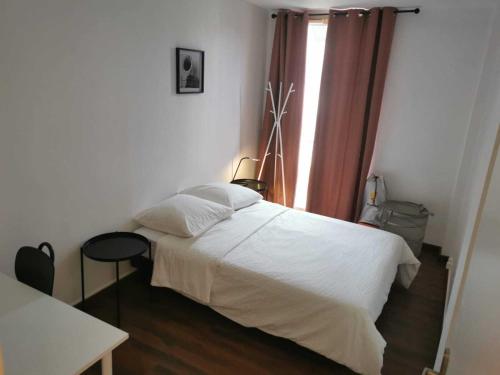 ein Schlafzimmer mit einem weißen Bett und einem Fenster in der Unterkunft Au Saint-Hubert, Appartement 3 chambres Valenton in Valenton