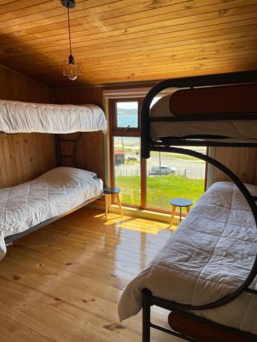 two bunk beds in a room with a window at Travesia Hotel & Tea in Ancud