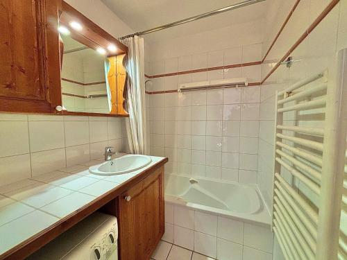 La petite salle de bains est pourvue d'un lavabo et d'une baignoire. dans l'établissement Les Menuires - 2 Pcs Cabine - 4/5 Pers - Wifi - Animaux admis - FR-1-452-256, aux Menuires