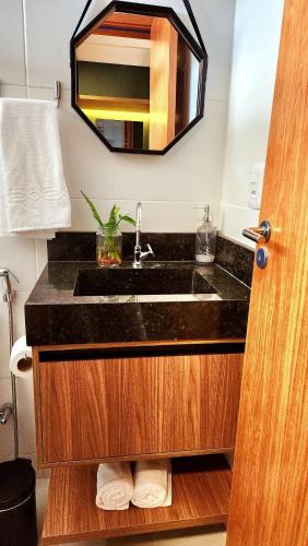 a bathroom with a sink and a mirror at Studio Incrível: Piscina, Wi-Fi, Pôr do Sol Mágico in Cabedelo