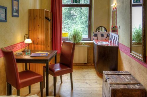 a room with a table and chairs and a kitchen at Gästehaus Mezcalero in Dresden
