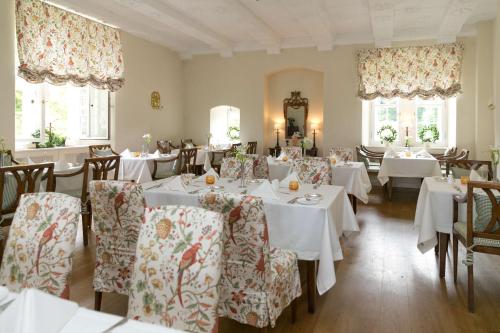 a dining room with white tables and chairs at Schlosshotel Münchhausen in Aerzen