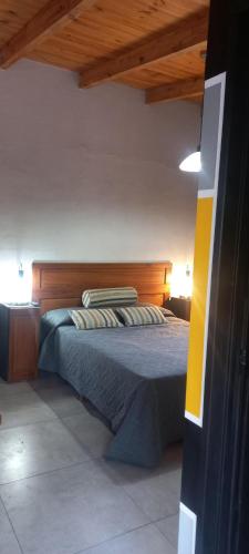 a bedroom with a bed with a wooden headboard at Úrsula, MACONDO in Cañada de Gómez