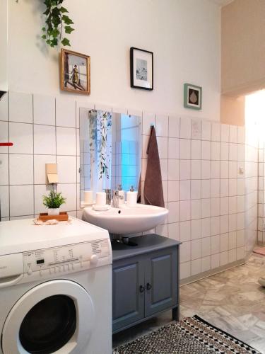 a bathroom with a washing machine and a sink at The Boho Hideaway in Leutsch in Leipzig