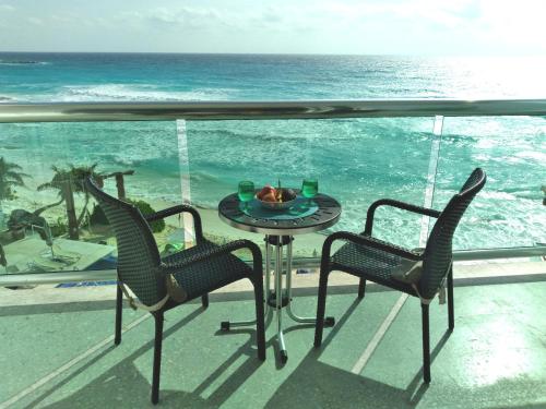 a table and chairs on a balcony with the ocean at Ocean Seaview Dream condo next to clubs in Cancún