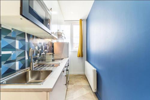 une cuisine avec un évier et un plan de travail dans l'établissement Magenta, Charmant & Moderne, à Villeurbanne