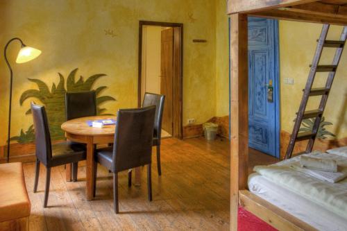 a dining room with a table and chairs and a bed at Gästehaus Mezcalero in Dresden