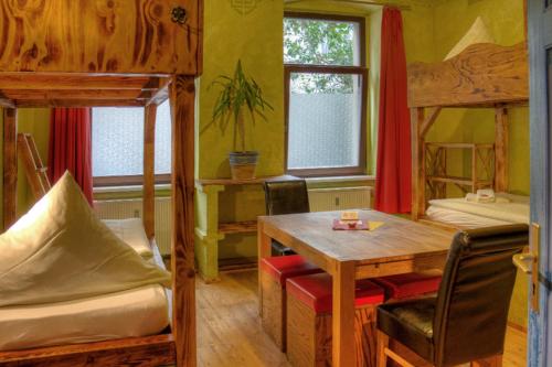 a room with two bunk beds and a table and chairs at Gästehaus Mezcalero in Dresden
