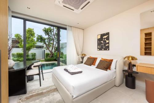 a bedroom with a white bed and a desk and a table at Luxury 3BR Villa Eden with Private Pool by TropicLook in Ban Pak Lak