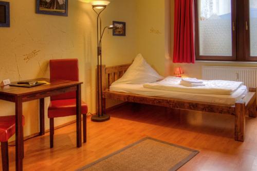 a bedroom with a bed and a table and a desk at Gästehaus Mezcalero in Dresden