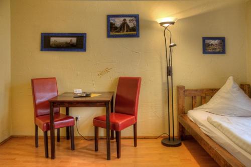 a room with a table and two chairs and a bed at Gästehaus Mezcalero in Dresden