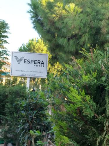 a sign in front of some bushes with a tree at Vespera hotel in Dalyan