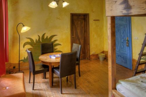 a dining room with a table and chairs and a bed at Gästehaus Mezcalero in Dresden