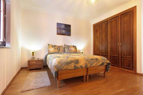 a bedroom with a bed and a wooden cabinet at Casa Africana in Vila Nova de Milfontes