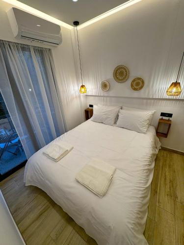 a bedroom with a white bed with two towels on it at Roro Center Suites in Patra