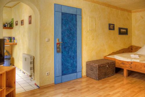 a room with a blue door in a room with a bed at Gästehaus Mezcalero in Dresden