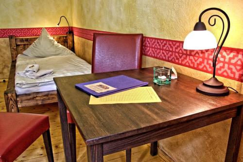a table with a lamp and a bed in a room at Gästehaus Mezcalero in Dresden