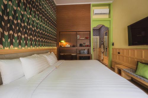 a bedroom with a large white bed in a room at Senglao Boutique Hotel Luang Prabang in Luang Prabang