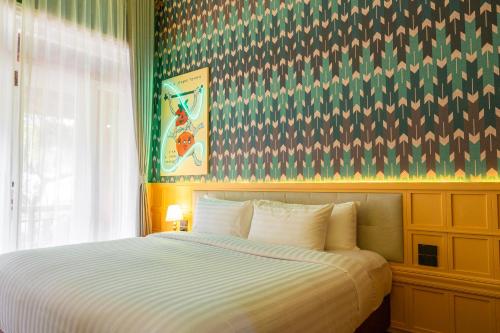 a bedroom with a large bed with a large window at Senglao Boutique Hotel Luang Prabang in Luang Prabang